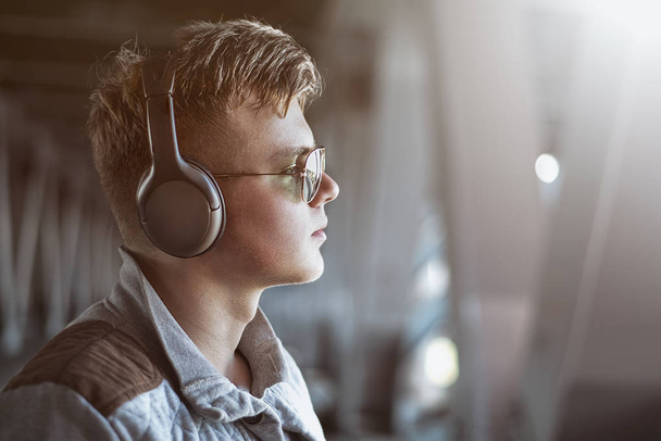 Retrato de un joven con estilo escuchando música con auriculares. Concepto de estilo de vida. concepto de música
 - Foto, imagen