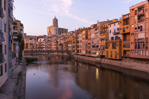 bunte gelbe und orangefarbene Häuser, die sich im Wasser des Onyar-Flusses spiegeln, in Girona, Katalonien, Spanien. - Foto, Bild