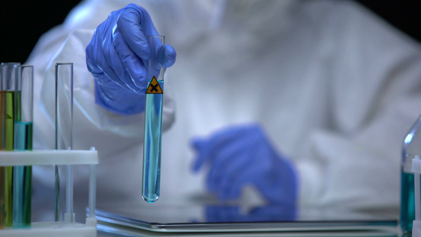 Chemielaborantin zeigt Röhre mit schädlichem Zeichen, Pestizidentwicklung - Filmmaterial, Video