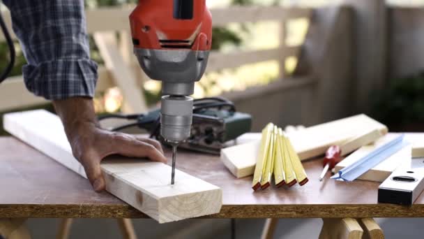 Falegname artigiano adulto con trapani elettrici fa un buco su un tavolo di legno. I lavori domestici lo fanno da soli. Filmati
. - Filmati, video