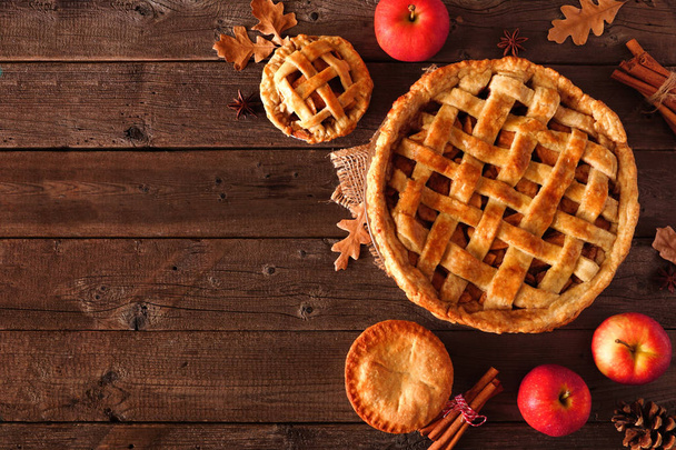 Homemade autumn apple pie corner border. Top view table scene over a rustic wood background with copy space. - Photo, Image