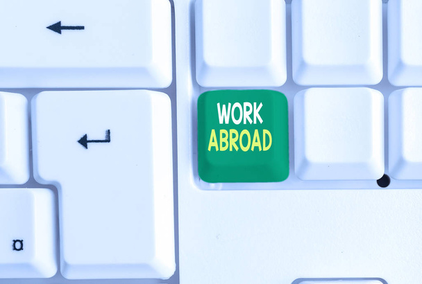 Conceptual hand writing showing Work Abroad. Business photo text Immersed in a foreign work environment Job Overseas Non Local White pc keyboard with note paper above the white background. - Photo, Image