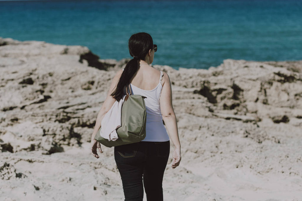 Gekleed vrouw het nemen van een wandeling op het strand - Foto, afbeelding