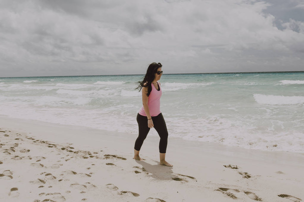 Femme habillée faisant une promenade sur la plage
 - Photo, image