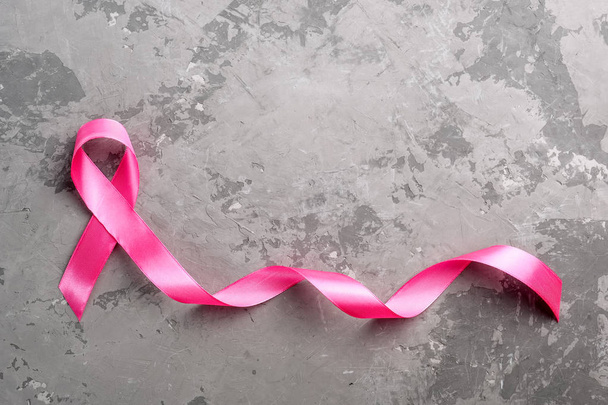 Pink ribbon on a concrete surface. Breast Cancer Awareness Month - Photo, Image