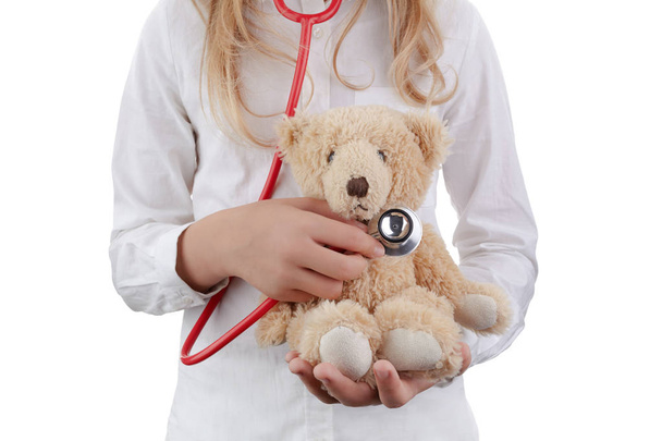 Kid girl playing doctor with plush toy as nursery on white background - Photo, Image