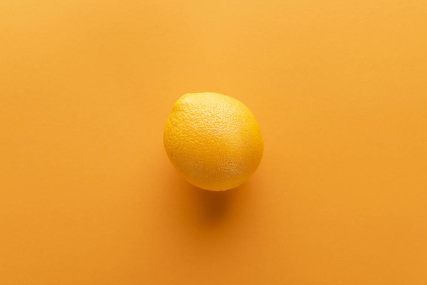 orange on color paper background - Φωτογραφία, εικόνα