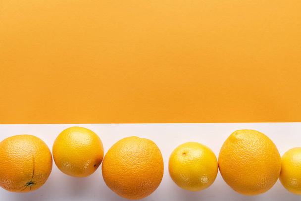 sinaasappels op kleur papier achtergrond - Foto, afbeelding