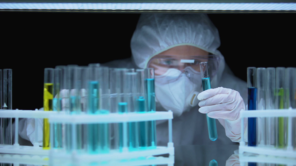 Professionelle Laborantin lässt Flüssigkeit im Reagenzglas fallen, medizinische Forschung - Filmmaterial, Video