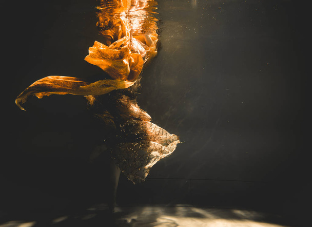 νεαρή γυναίκα κολύμπι μόνη με ύφασμα μόδας υποβρύχιας ανώνυμης περιήγησης - Φωτογραφία, εικόνα