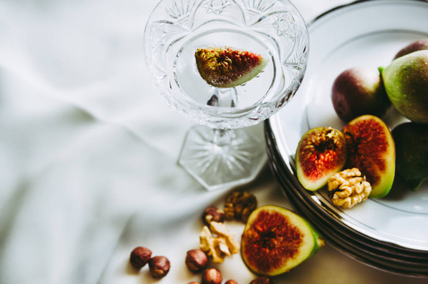 beautiful crystal champagne glasses with figs and nuts on table - Foto, immagini