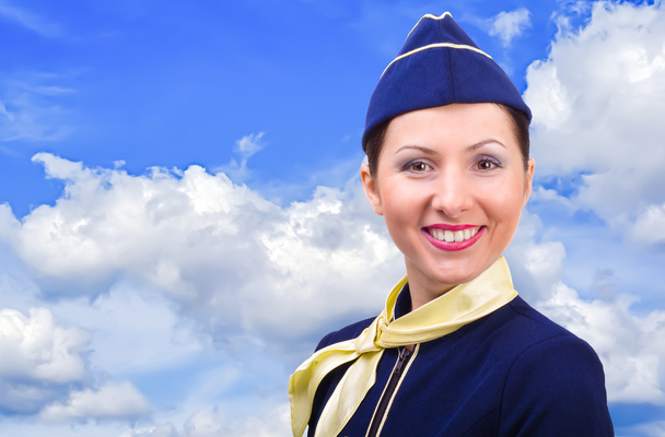 Beautiful smiling stewardess on a background sky - Valokuva, kuva