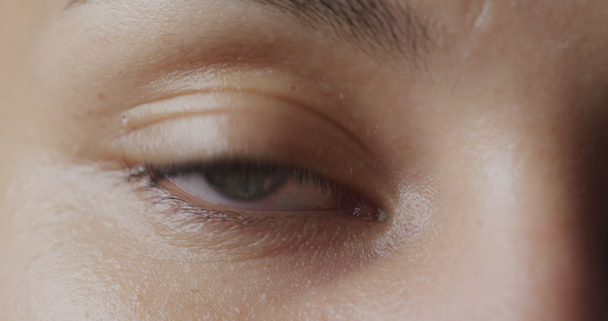 Pohled zepředu zblízka detail zeleného oka ženy vypadající jako přímý fotoaparát a blikající - Záběry, video