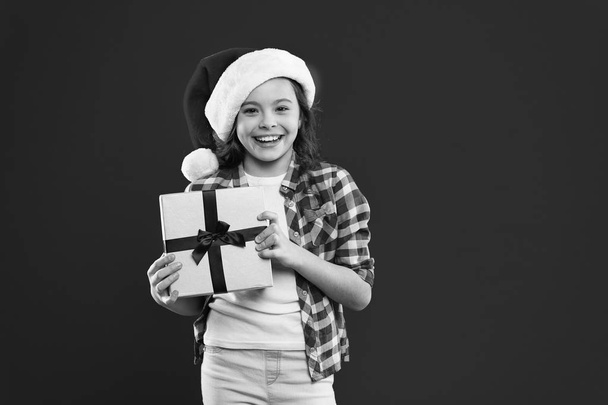 Happy winter holidays. Small girl. Present for Xmas. Childhood. Christmas shopping. Little girl child in santa red hat. New year party. Santa claus kid. Express positivity. copy space. - Zdjęcie, obraz
