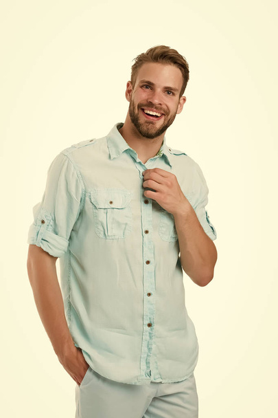It is hot here. Man handsome bearded guy smiling on white background isolated. Guy cheerful smile macho feels hot while unbuttoning shirt. Positive emotions. Brilliant smile. Man with sincere smile - Photo, Image