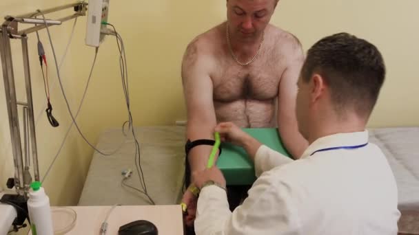 Male doctor examines a patient with a medical device. - Кадри, відео
