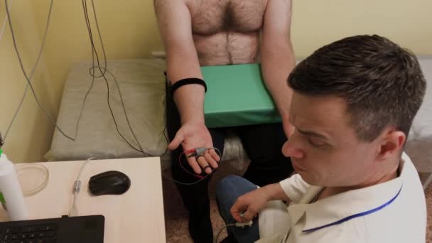 Ο άνδρας γιατρός εξετάζει έναν ασθενή με ιατρική συσκευή. - Πλάνα, βίντεο