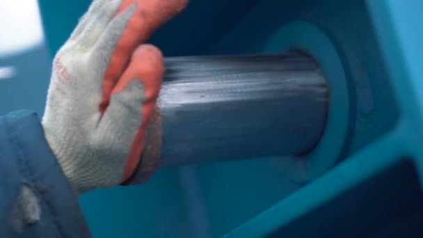 Close-up άποψη του εργαζομένου χέρι σε προστατευτικό γάντι ρύθμιση μέχρι ένα μεγάλο κύλινδρο χάλυβα στην ανύψωση γερανό. Κλιπ. Έννοιες κατασκευής και λειτουργίας - Πλάνα, βίντεο