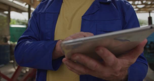 Front view close up of a mature Caucasian male farmer on an organic farm, using a tablet computer - Filmmaterial, Video
