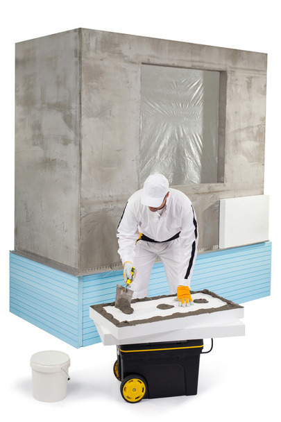 Trabalhador espalhando uma massa de vidraceiro em um painel de isolamento
 - Foto, Imagem