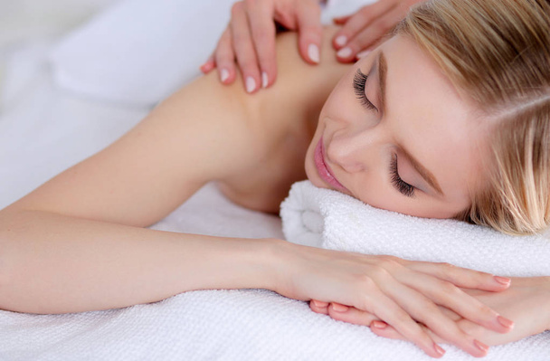 Young woman lying on a massage table,relaxing with eyes closed. Woman. Spa salon - Фото, изображение