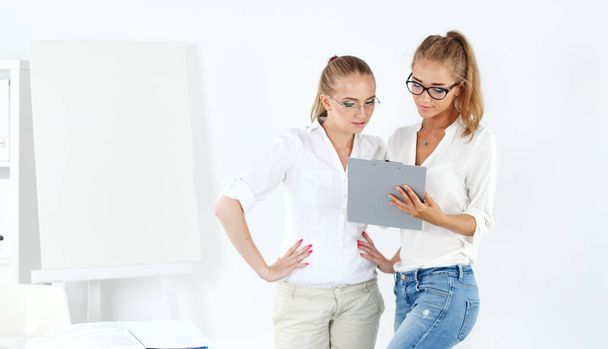 Two businesswomen having informal meeting in modern office - Фото, изображение