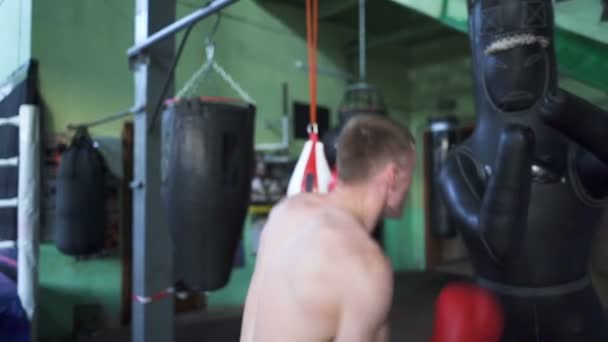 Mies ammattilaisnyrkkeilijä taistelee nyrkkeilysäkki, vakaa laukaus. Hidastettu liike, itsepuolustusryhmä
 - Materiaali, video