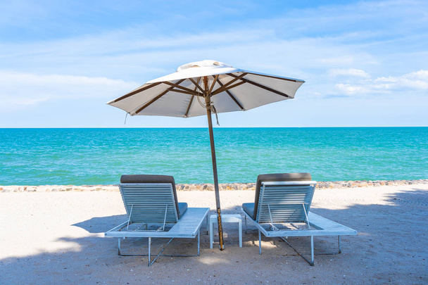 Belo guarda-chuva e cadeira em torno da praia mar oceano com sk azul
 - Foto, Imagem