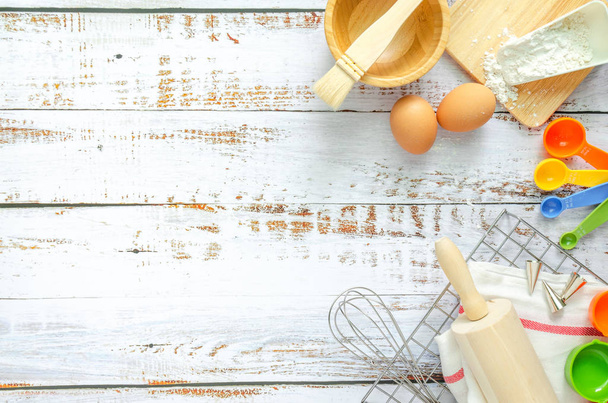 Випічка посуду та інгредієнти для приготування хлібобулочних виробів на білому дерев'яному фоні. Зображення пробілів тексту, вид зверху
. - Фото, зображення