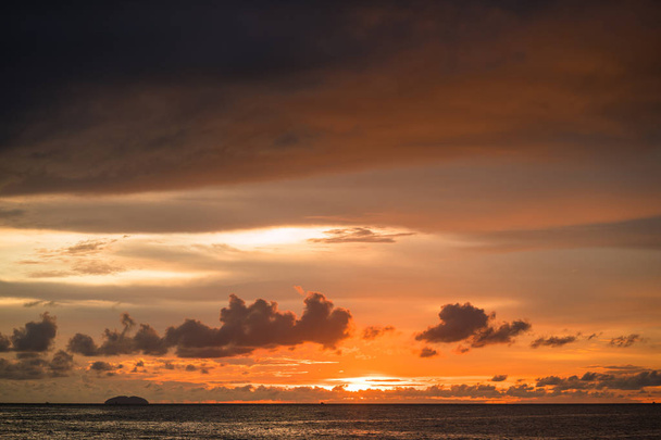 Parlak turuncu gökyüzü ve güneşin ışığı. Gün batımında gökyüzü arka planı - Fotoğraf, Görsel