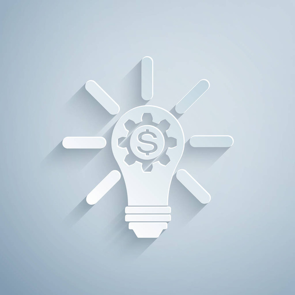 Papier geschnittene Glühbirne mit Zahnrad innen und Dollar-Symbol isoliert auf grauem Hintergrund. Fintech-Innovationskonzept. Papierkunst. Vektorillustration - Vektor, Bild