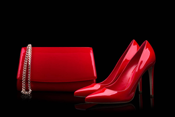 Rode tas en rode schoenen op een zwarte achtergrond - Foto, afbeelding