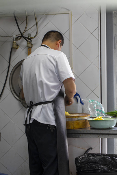 Chef in cucina, si prepara a cucinare, tagliando le patate
 - Foto, immagini
