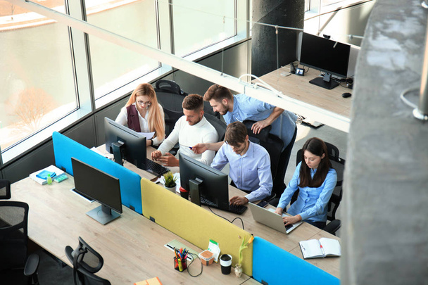 Pohled shora mladých moderních kolegů v neformálně nosit, spolupracují při trávení času v kanceláři. - Fotografie, Obrázek