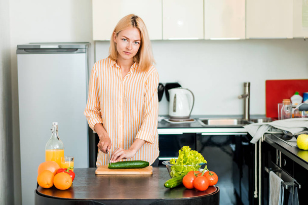 Молодая женщина готовит на кухне - Фото, изображение