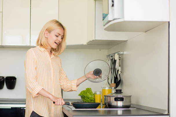 Blonde woman preparing dinner - Фото, изображение