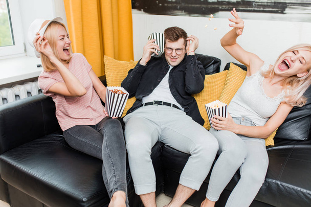 Cheerful group of friends eating popcorn at home - Φωτογραφία, εικόνα