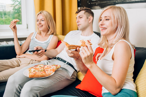 Friends eating pizza and talking, spending time together at home - Foto, Imagem