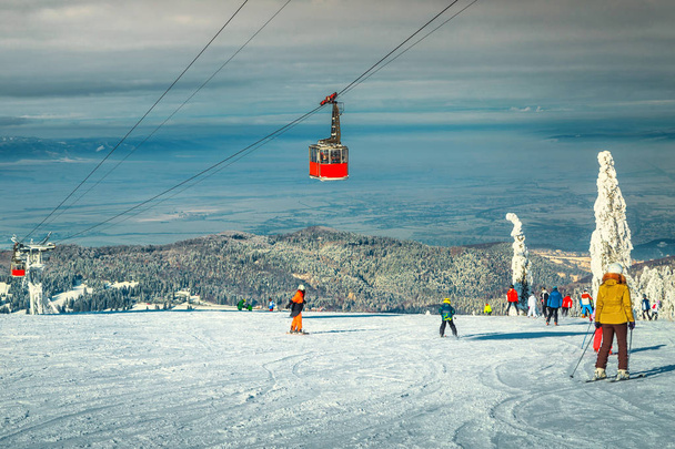 スキーヤーとケーブルカー付きの冬のスキーリゾート、トランシルバニア、ルーマニア - 写真・画像