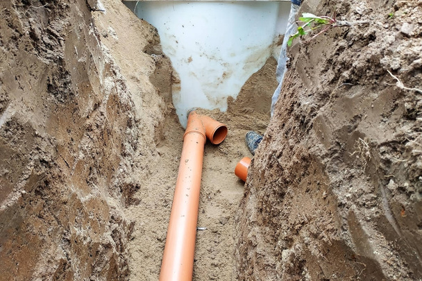 田舎のマスターロックスミスによるサンプへの下水管の供給. - 写真・画像