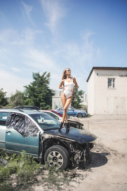Blonde girl on the car - Foto, afbeelding