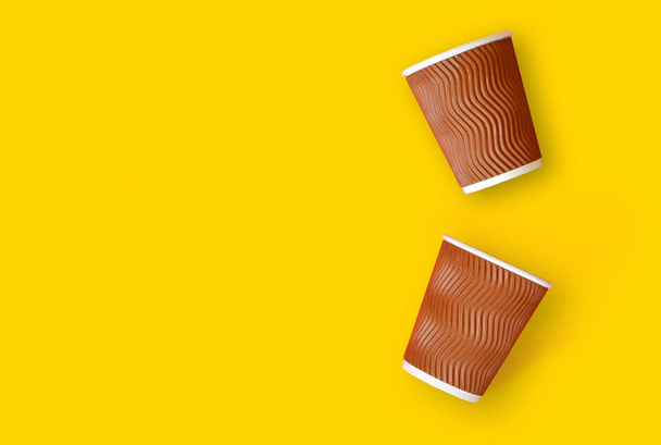 Coffee to go concept. Two paper cups of coffee on a yellow background. Template with copy space. - Photo, Image