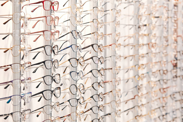 row of stylish glasses at an opticians - 写真・画像