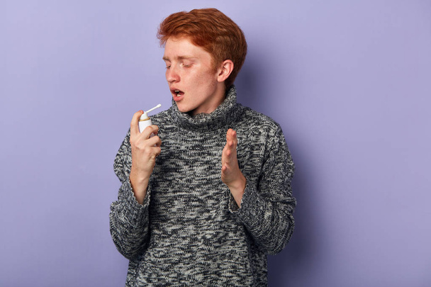 young man using inhaler. close up side view photo. - Zdjęcie, obraz