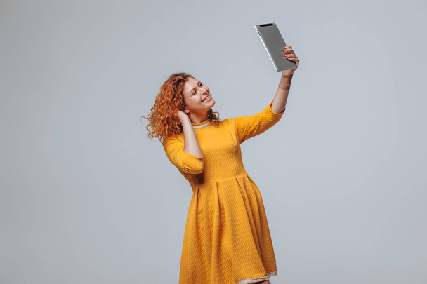 rothaariges Mädchen macht ein Selfie auf dem Tablet - Foto, Bild