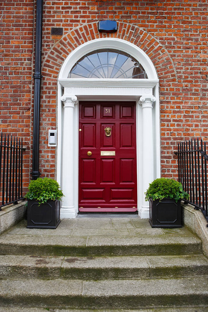 Punainen ovi Dublinissa, Irlannissa. Kaareva Georgian oven talon edessä
 - Valokuva, kuva