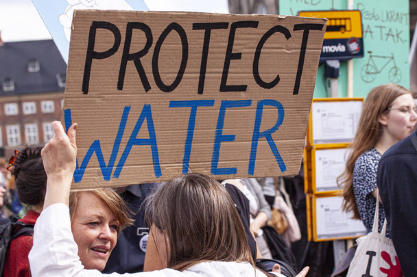 Manifestanti che protestano contro il cambiamento climatico con striscioni che dicono Proteggere l'acqua
.  - Foto, immagini