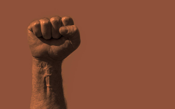 Raised clenched fist with plenty of copy space text or other images. Stock photo with socialism, communism, revolution, workman and power to the people concept.  - Photo, Image