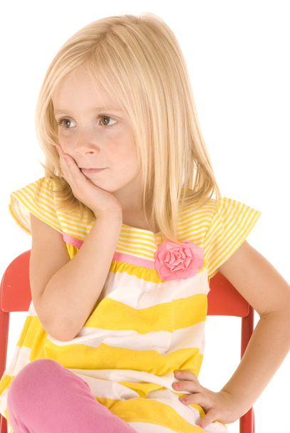Nuori blondi tyttö istuu punaisessa tuolissa lepää päänsä hänen
 - Valokuva, kuva