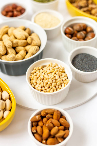 Various Nuts and Seeds on White Background in the Bowls - Image - Photo, image